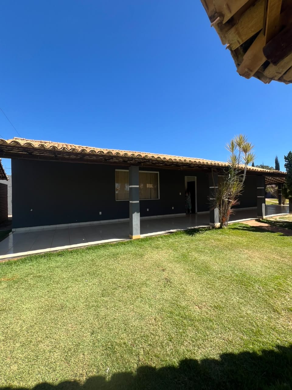 Varanda coberta da casa sede com gramado frontal